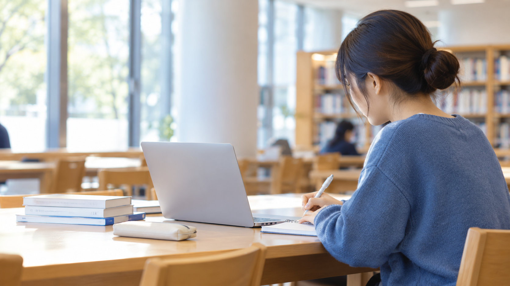 大学の図書館で学生がノートパソコンを使って学習している様子